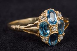 An unmarked 18 ct yellow gold diamond and aquamarine ring Of domed target form. 1.2 cm high.