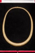 An unmarked (tests as 18 ct) gold articulated torque necklace In fitted case. 45 cm long.