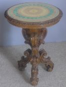 An Italian carved wooden circular tripod table The decoratively inset top above the scroll carved