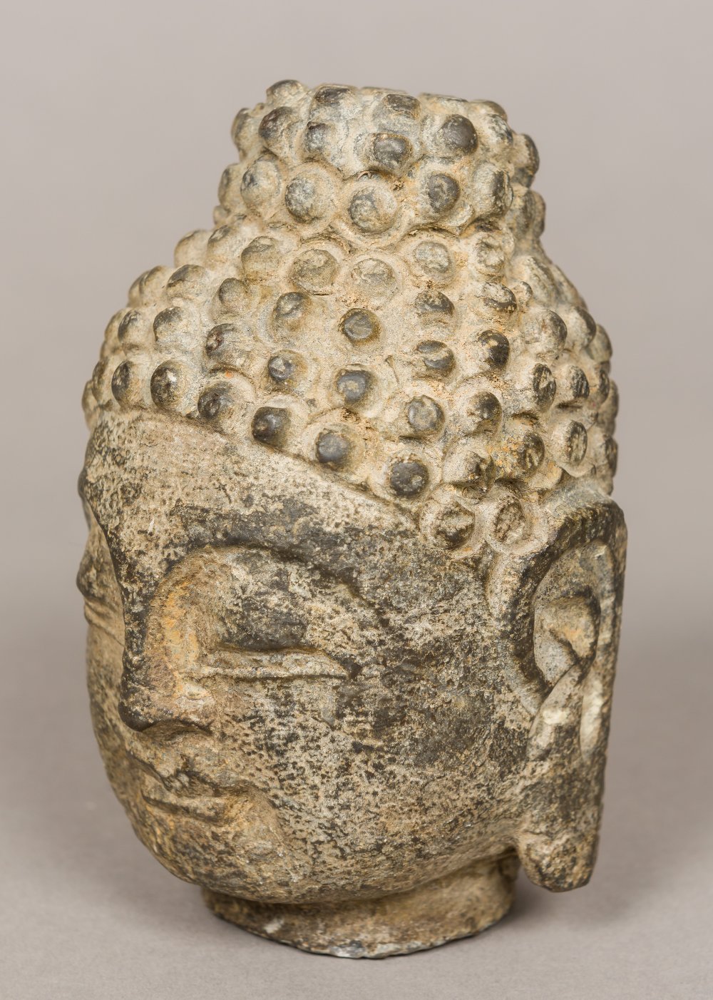 A South-East Asian carved stone Buddha's head Typically worked. 11 cm high.