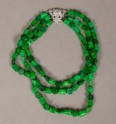 A carved green jade bead three strand necklace With Art Deco diamond set white metal clasp.