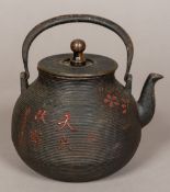 A 19th century Japanese cast iron teapot Of ribbed bulbous form with painted cast calligraphic and