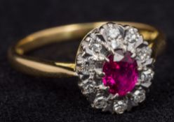 An 18 ct gold ruby and diamond set cluster ring Size Q, cased.