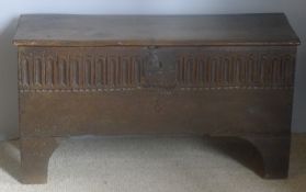 A 17th/18th century oak plank coffer The hinged rectangular top above the carved front with iron