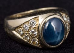 An unmarked gold star sapphire and diamond ring The thick band centred with the cabochon star
