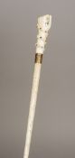 A 19th century whalebone walking stick The marine ivory handle carved as a clenched fist holding an