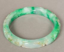 A large Chinese carved jade bangle The exterior carved with fish and mythical beasts amongst