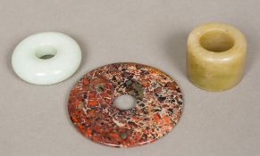 A pale green jade roundel Together with another specimen stone roundel; and an archers ring.