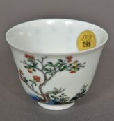 A Chinese Kangxi famille verte tea bowl Finely painted with a flowering shrub opposing calligraphic