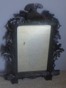 A 19th century Black Forest carved wall glass The bevelled mirror plate surrounded by the