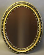 An Irish 19th century ebonised and gilded bejewelled mirror The oval plate within a typical frame.