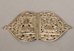An Indian white metal buckle Worked and pierced with figures. 13 cm wide.