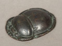 An Egyptian bronze scarab beetle seal The underside worked with four bands of hieroglyphs.