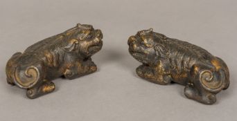 A pair of Chinese patinated bronze scroll weights Each formed as a dog-of-fo,