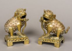 A pair of Chinese gilt bronze temple lions Typically modelled, standing on plinth bases.