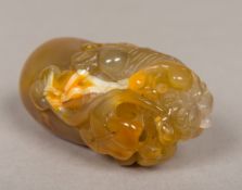 A carved agate pebble Decorated with a dog-of-fo with a carved ball inside his mouth. 9.5 cm long.