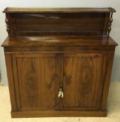 An early 19th century rosewood chiffonier The three quarter pierced brass galleried top supported