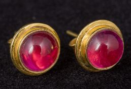 A pair of 18 ct gold and tourmaline set stud earrings Cabochon cut. Approximately 1 cm diameter.