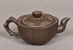 A Yixing pottery teapot Of lobed form, impressed marks to base. 7 cm high.