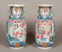 A pair of 19th century Canton famille rose porcelain vases Each serpentine flared neck with twin