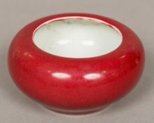 A Chinese porcelain bowl Of squat form with allover red glaze,