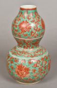 A Chinese porcelain double gourd vase Worked with lotus strapwork on a green ground,