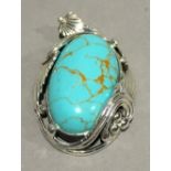 A silver and turquoise pendant