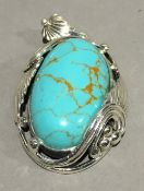 A silver and turquoise pendant
