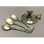 A silver chamberstick and three spoons