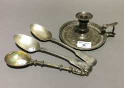 A silver chamberstick and three spoons
