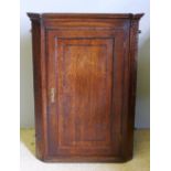 A George III inlaid oak corner cupboard