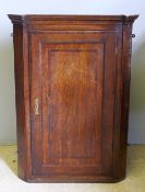 A George III inlaid oak corner cupboard