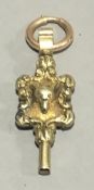 An unmarked yellow metal fox mask decorated fob watch key