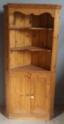 A modern pine corner cupboard