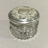 A silver topped cut glass jar