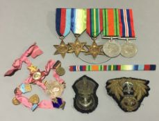 A quantity of WWII medals, cap badges, etc.