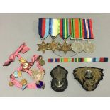 A quantity of WWII medals, cap badges, etc.