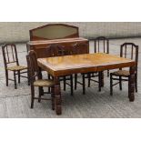 An early 20th century French oak dining set, comprising a dining table, sideboard,
