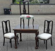An early 20th century oak drawer leaf dining table and three chairs