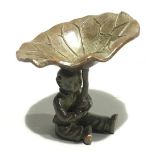 A bronze figure formed as a boy holding a lily pad