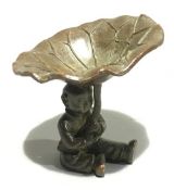 A bronze figure formed as a boy holding a lily pad