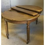 A Victorian oak oval three leaf extending dining table