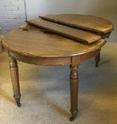 A Victorian oak oval three leaf extending dining table