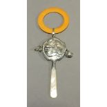 A silver rattle with a mother-of-pearl handle