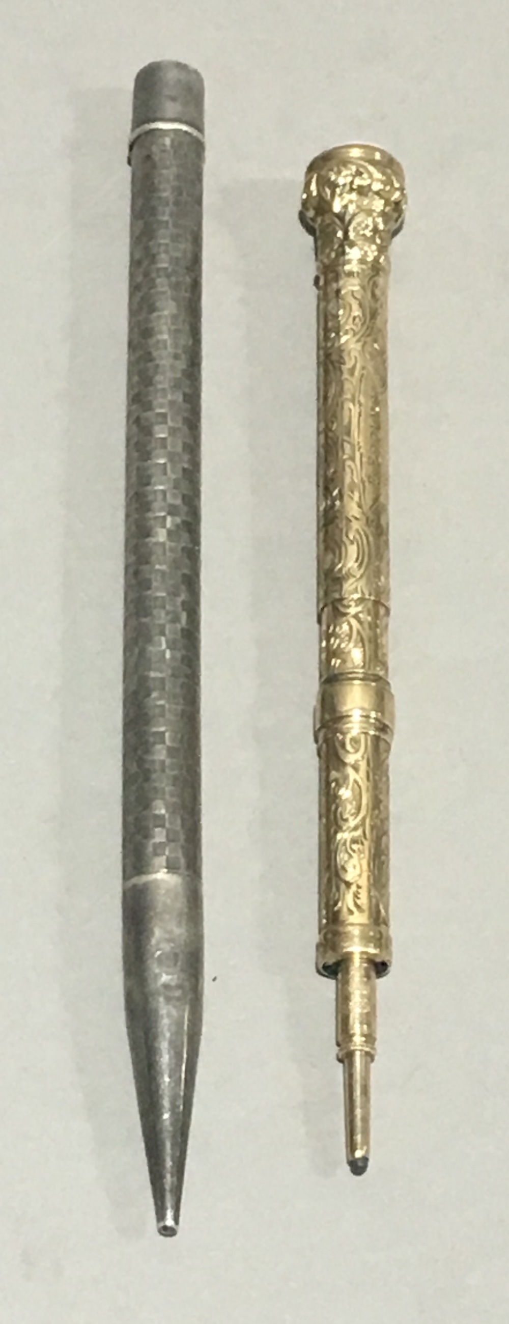 A Victorian unmarked yellow metal propelling pencil and a sterling silver propelling pencil