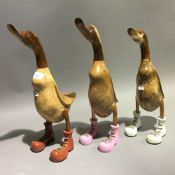 Three wooden ducks in wellington boots