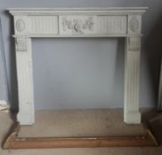 A painted fire surround and a brass fender