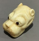 A bone netsuke formed as a dog's head