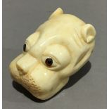 A bone netsuke formed as a dog's head