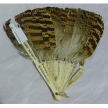 A decorated feather and bone fan